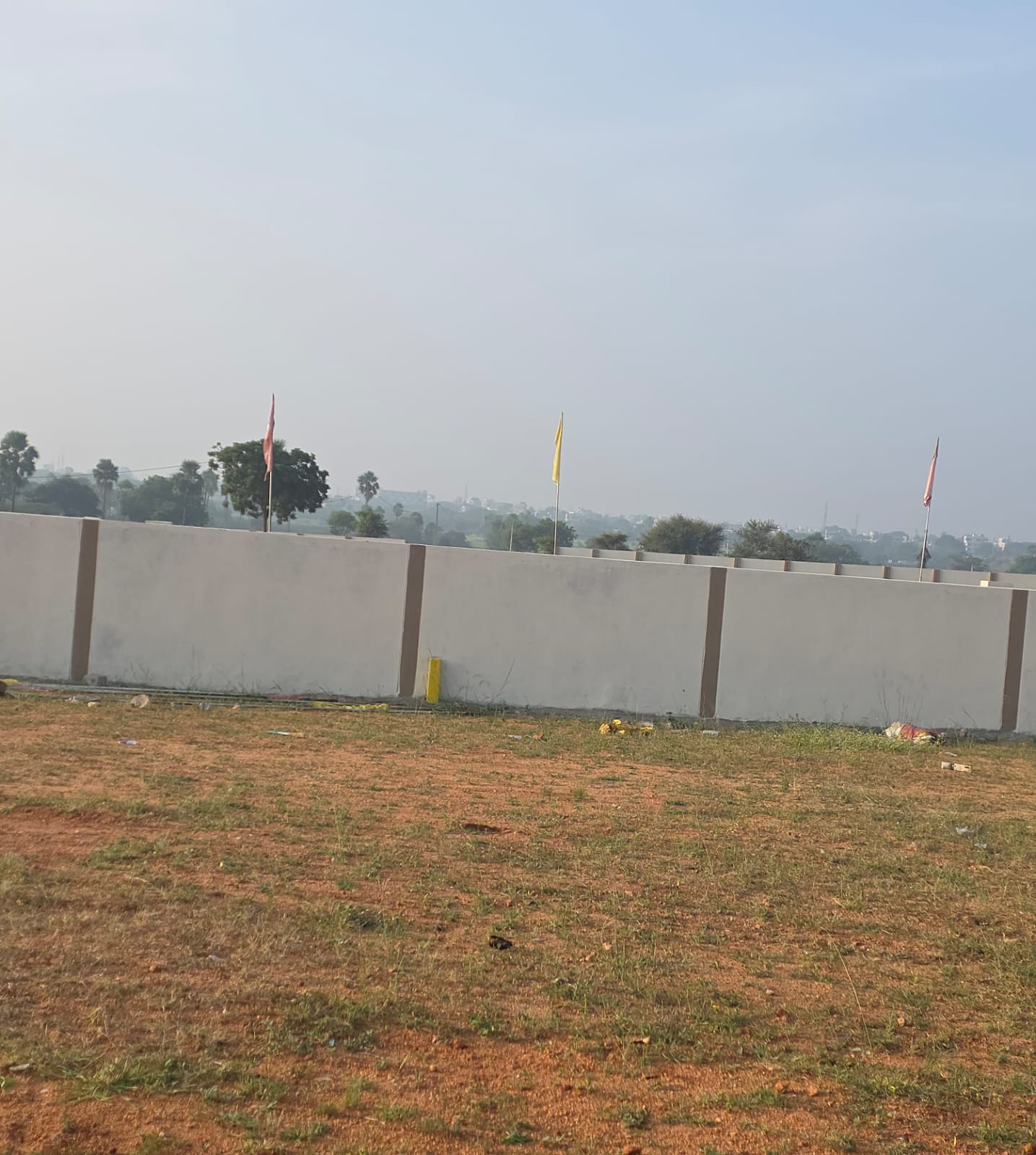 Long run of precast concrete compound wall along the Eastern Meadows boundary