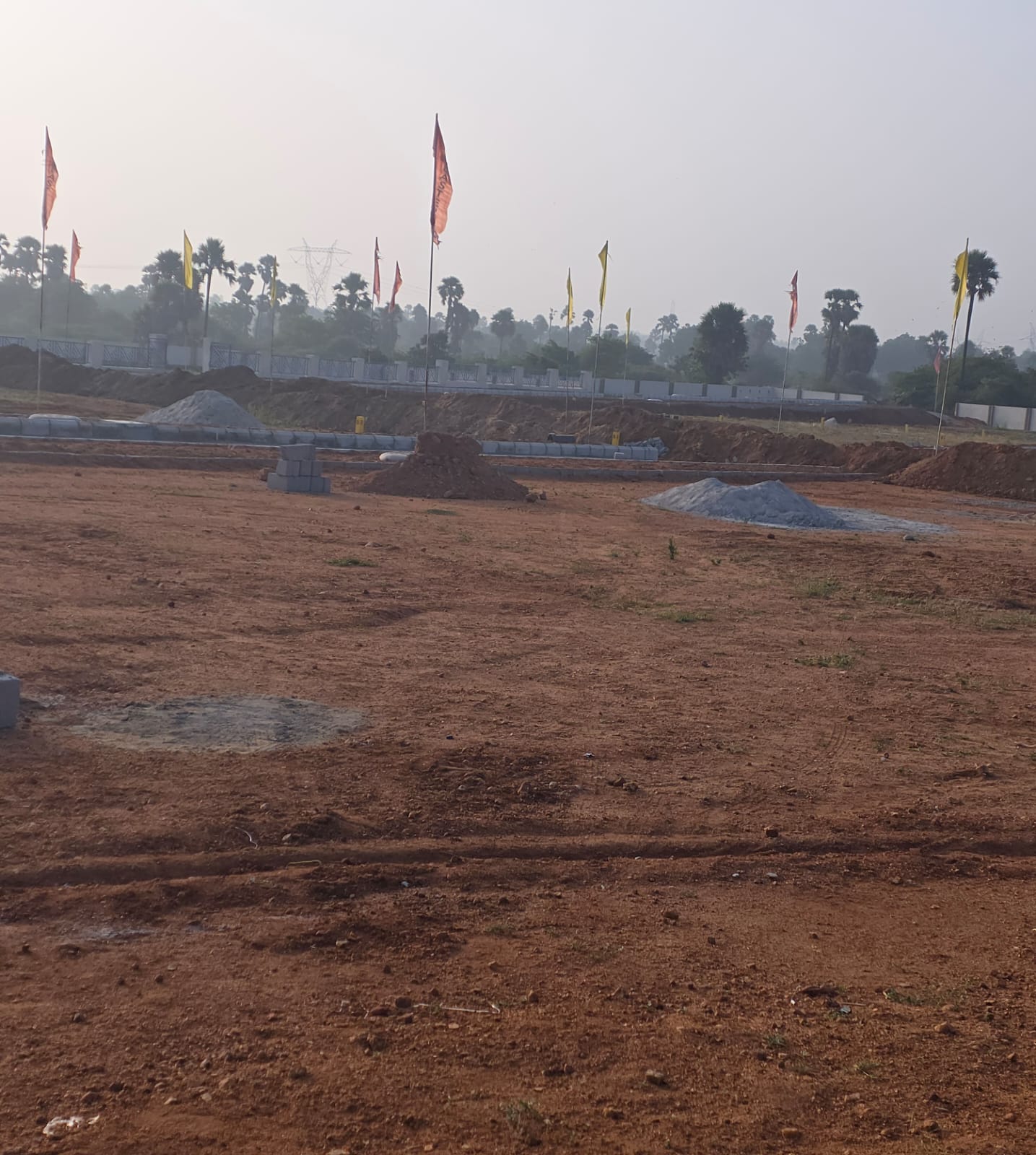 Plot area at Eastern Meadows with aggregate heaps and chamber covers set into the ground for underground services